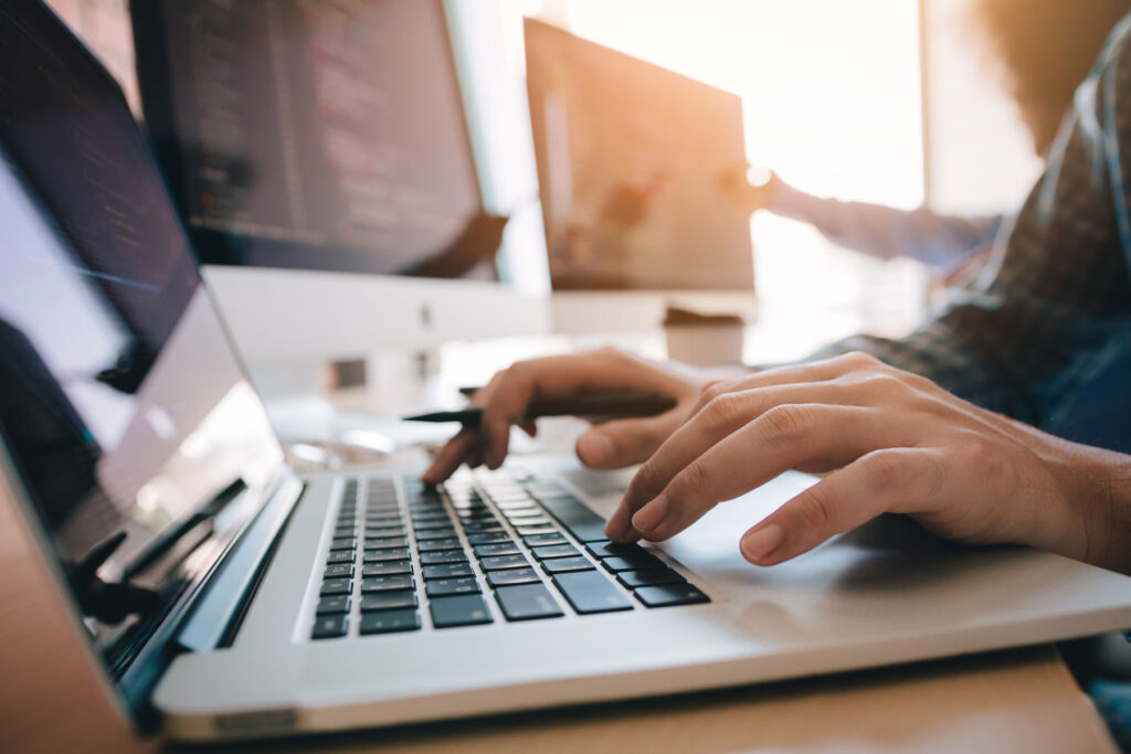 Hands resting on the keyboard of a laptop computer.